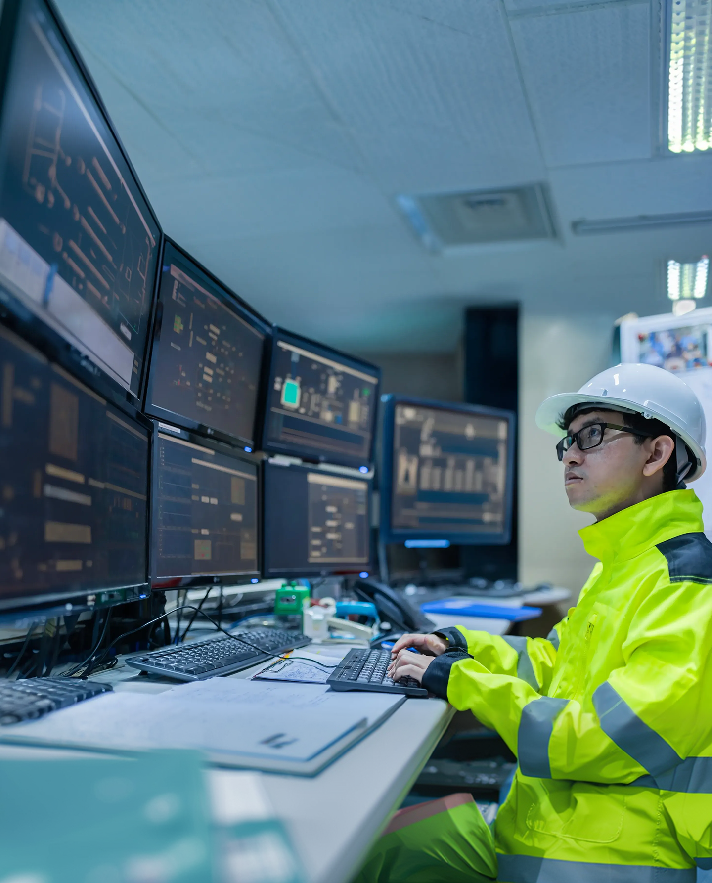 An engineer working at a computer workstation with multiple monitors.